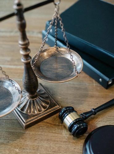 From above of judicial symbols consisting of Scales of Justice and small judge hammer with curly handle